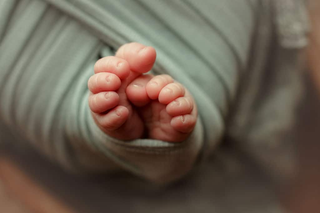 tiny newborn feet wrapped up tight