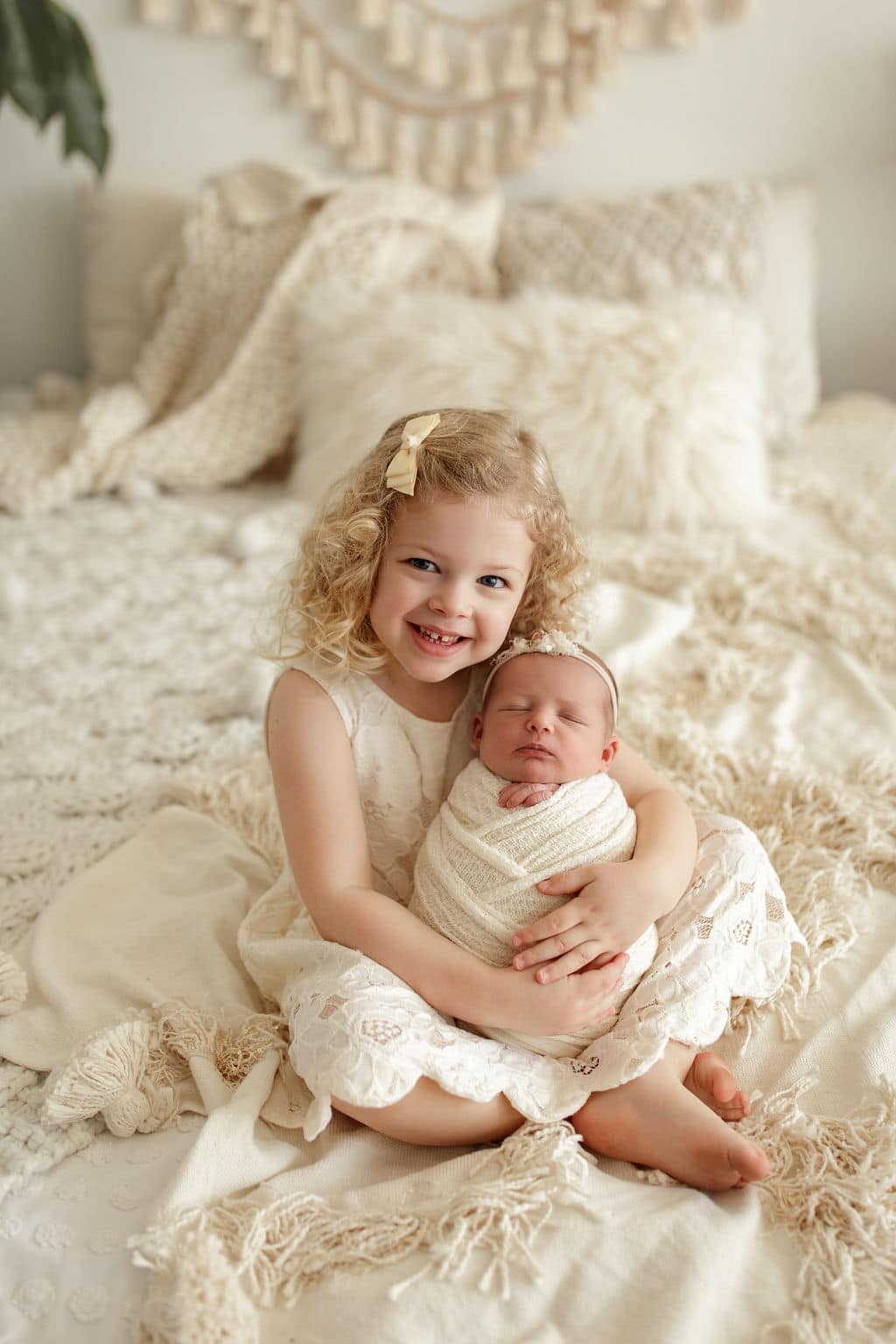 big sister holds her newborn sister 