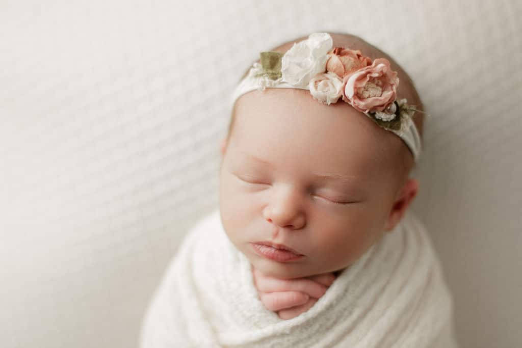 sweet newborn baby girl, swaddled and asleep