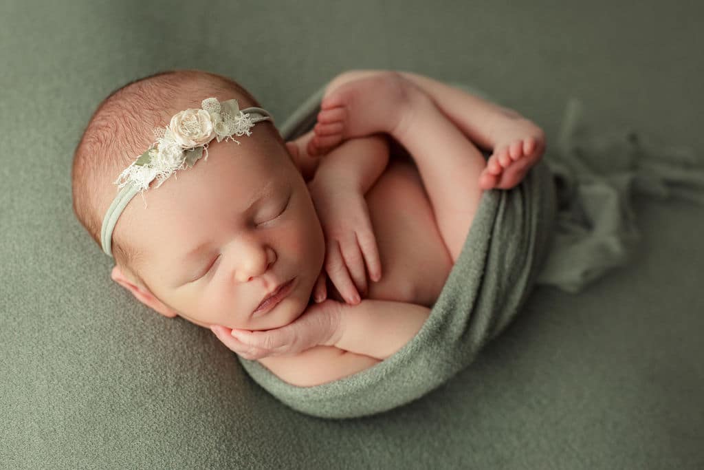 baby girl swaddled in green