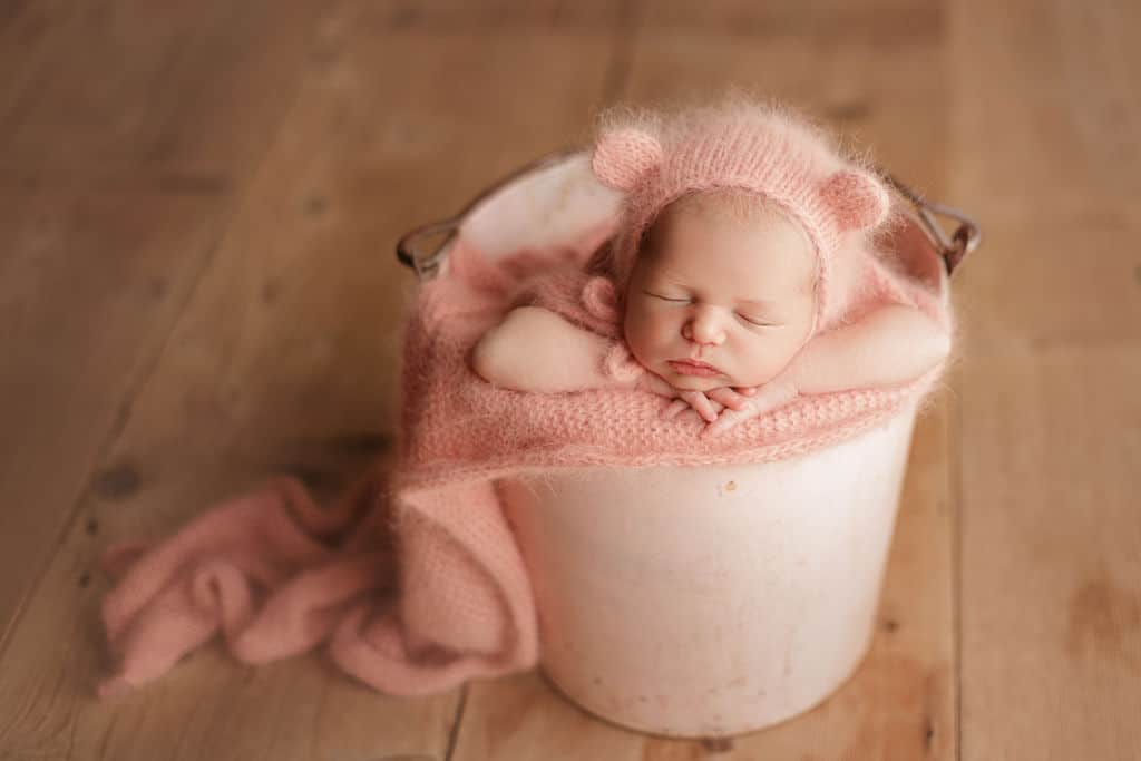 baby in pink teddy bear ear bonnet 