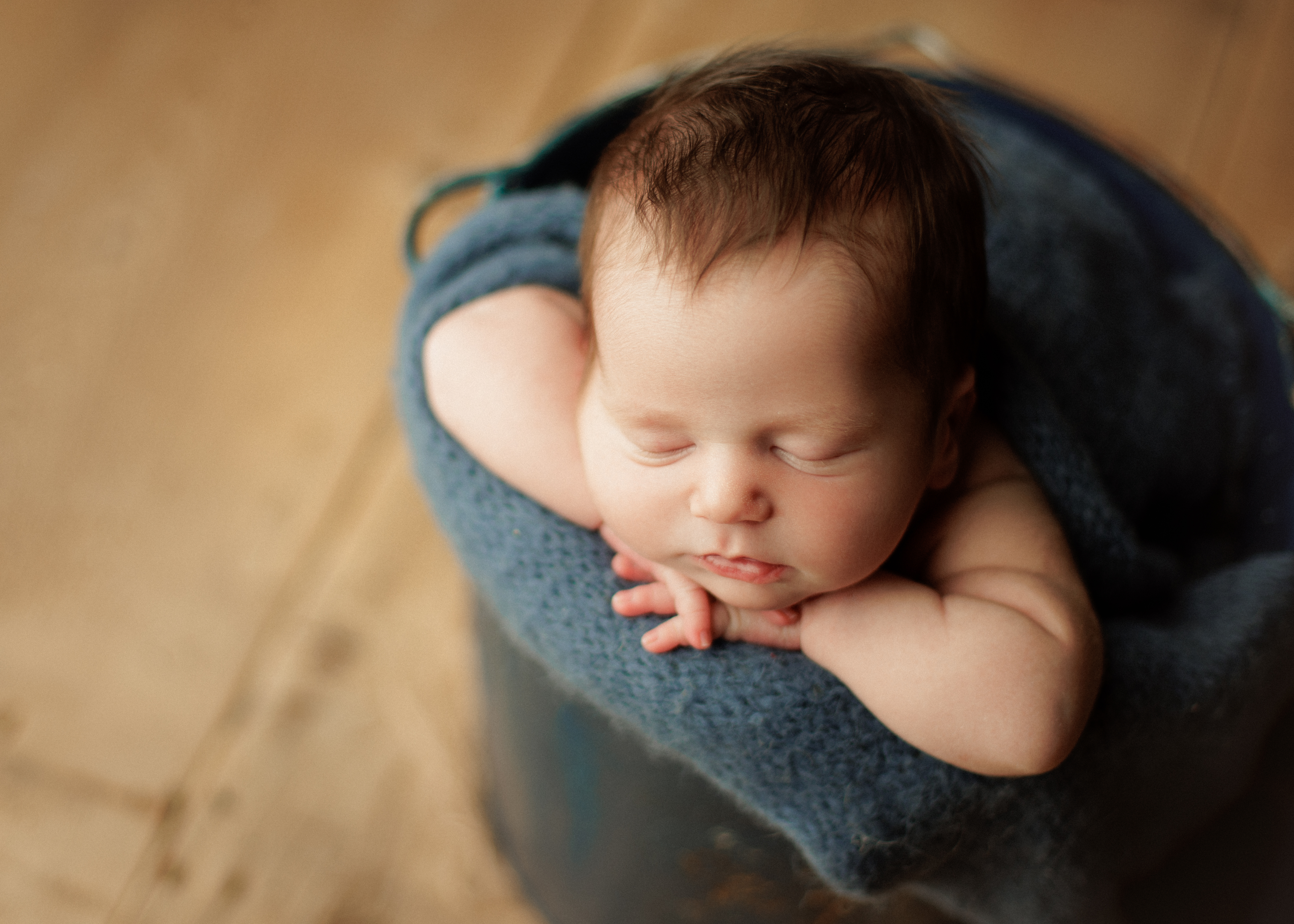 baby in a bucket newborn pose